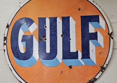 Vintage Gulf gas station sign on wall.