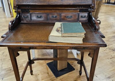 Antique wooden writing desk with open drawers.