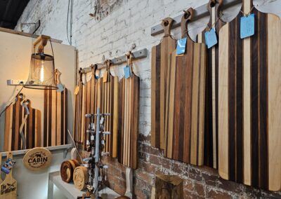 Wooden cutting boards displayed in a rustic shop setting.