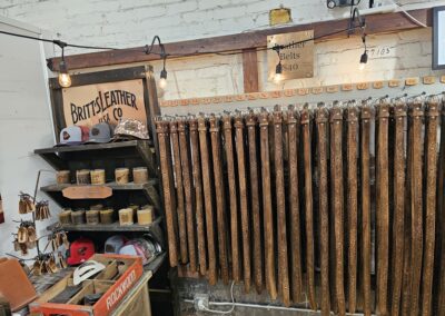 Vintage leather belts displayed on rustic market stall