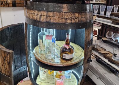 Wine bottles displayed inside a glass barrel table.