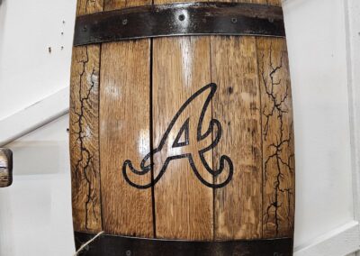 Vintage wooden barrel with decorative metal bands on shelf.