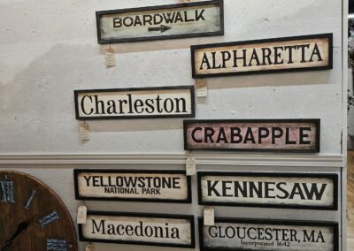 Wall with various destination wooden signs and a clock.