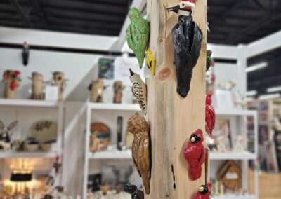 Colorful bird figurines on wooden perch in store